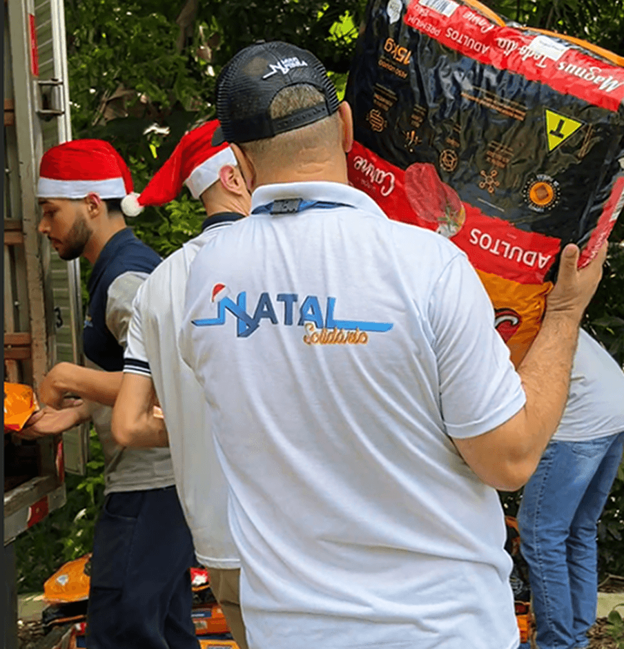 Pessoa carregando o pacote de ração na ação solidária